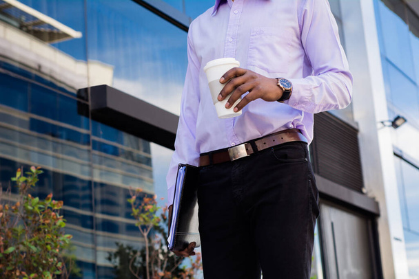 Portrait of afro businessman taking a break from work and drinking a cup of coffee outdoors. Business concept. - Foto, immagini