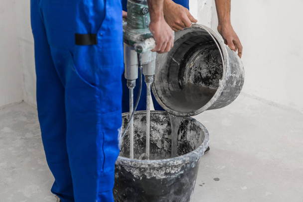 Two men knead cement with a construction mixer - Fotografie, Obrázek