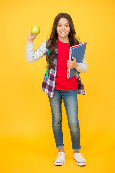 Eating well is good for your mental health. Happy child hold apple and books. Brain food. Natural diet. Dental health. Teeth hygiene. Health education. Healthy food in school thats really cool - Photo, image
