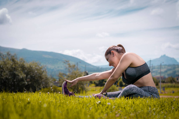 young latina woman stretching her muscles to start a training routine - Photo, Image