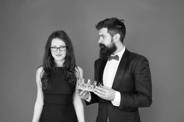 Awarding ceremony. Prom couple. Couple in love red background. Couple of sensual woman and bearded man with crown. Business couple in formalwear. Ceremonial reception. Holiday celebration - Fotografie, Obrázek