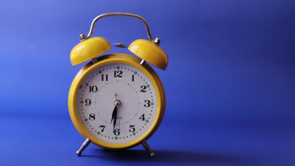 Reloj despertador amarillo retro que activa la alarma y la alarma de parada manual - Metraje, vídeo