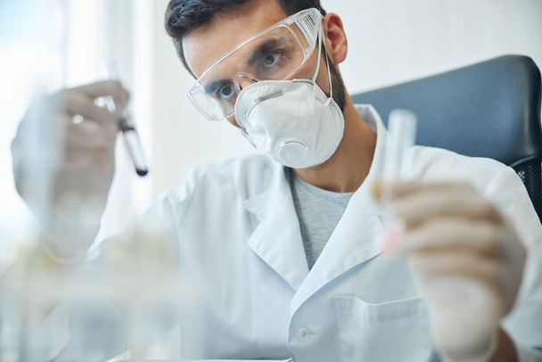 Biochemist examining biological substances in a laboratory - Foto, afbeelding