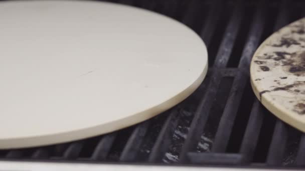 Préparation de pizzas grillées individuelles sur un barbecue à gaz extérieur. - Séquence, vidéo