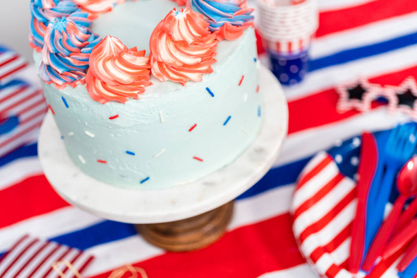 Czerwony, biały i niebieski okrągły tort waniliowy z lukrem maślanym na obchody 4 lipca. - Zdjęcie, obraz