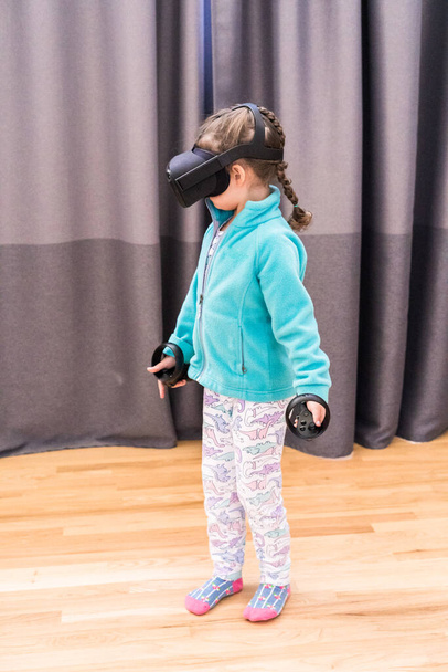 Pieni tyttö leikkii VR lapset peli olohuoneessa. - Valokuva, kuva