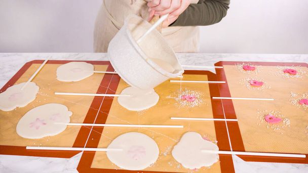 Giet gekarameliseerde suiker op siliconen matten om zelfgemaakte lolly 's te maken. - Foto, afbeelding