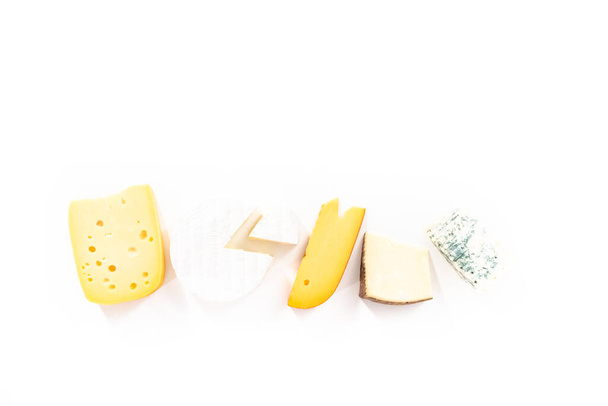 Vielzahl von großen Keilen Gourmet-Käse auf weißem Hintergrund. - Foto, Bild