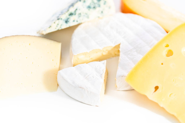 Vielzahl von großen Keilen Gourmet-Käse auf weißem Hintergrund. - Foto, Bild