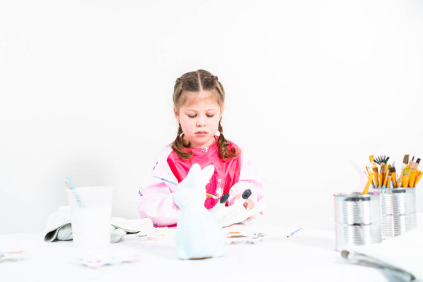 Маленька дівчинка працює над своїм мистецьким проектом дистанційного навчання вдома під час COVID-19 pendemic
. - Фото, зображення