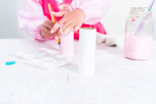 Bambina che fa un unicorno dal rotolo di carta igienica e carta artigianale. - Foto, immagini