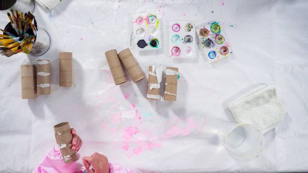 Leżeć płasko. Papierkowa robota dla dzieci. Malowanie pustych rolek papieru toaletowego farbą akrylową do tworzenia błędów papierowych. - Zdjęcie, obraz