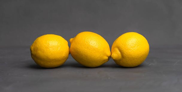 yellow lemons on dark gray background - Foto, Imagem