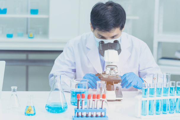 Bilim adamı covid-19 virüs kimya araştırması biyoteknoloji antikor örneği laboratuvarı virüse karşı aşı üretiyor. Bilim adamı mikroskoba bakıyor, bilim test tüpü kimya laboratuvarını analiz ediyor. - Fotoğraf, Görsel