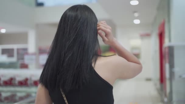 Jonge Aziatische dame dragen masker duwen boodschappenwagentje, draaien zich om en glimlach uitzicht van achteren bij supermarkt tijdens covid-19 corona virus pandemie. goederen leveren aan een nieuw normaal, gelukkig leven - Video