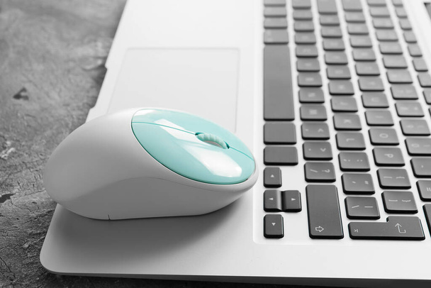 Modern PC mouse on laptop, closeup - Foto, afbeelding