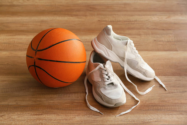 М'яч для гри в баскетбол і взуття на підлозі в спортзалі
 - Фото, зображення
