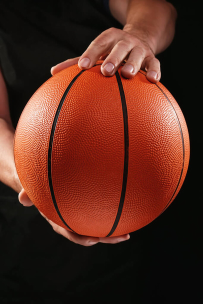 Hands of basketball player with ball on dark background - Foto, Imagem