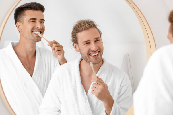 gelukkig gay paar poetsen tanden in badkamer - Foto, afbeelding