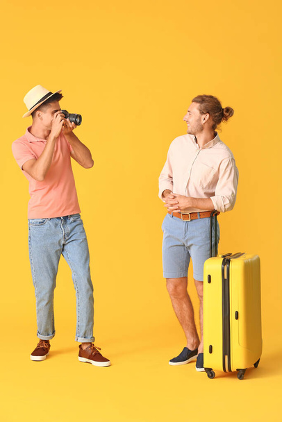 Couple of gay tourists on color background - Photo, Image
