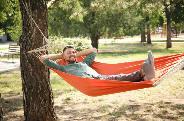 Hombre guapo relajándose en la hamaca al aire libre - Foto, Imagen
