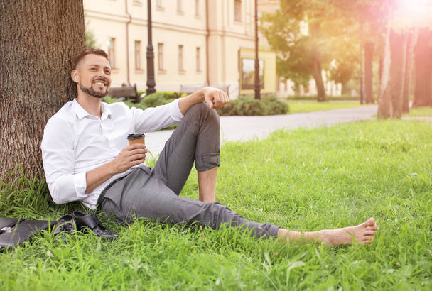 Hombre de negocios guapo relajándose en el parque - Foto, imagen