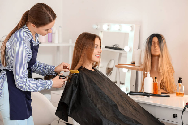 Friseur arbeitet mit junger Frau im Schönheitssalon - Foto, Bild