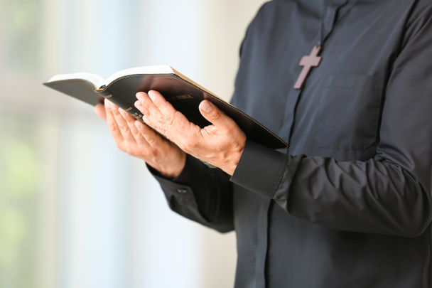 Мужчина священник с Библией дома, крупный план - Фото, изображение