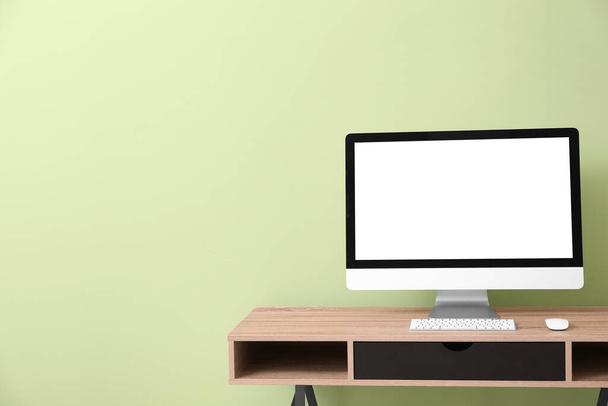 Moderne PC monitor op tafel in de buurt van kleur muur - Foto, afbeelding