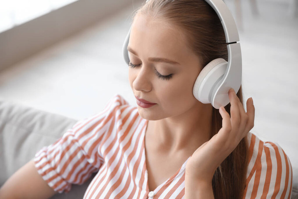 Uykulu genç kadın evde müzik dinliyor. - Fotoğraf, Görsel