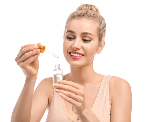 Schöne junge Frau mit kosmetischem Öl auf weißem Hintergrund - Foto, Bild
