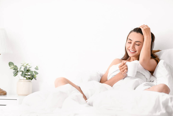 Seductive woman drinking coffee in bed at home - Valokuva, kuva
