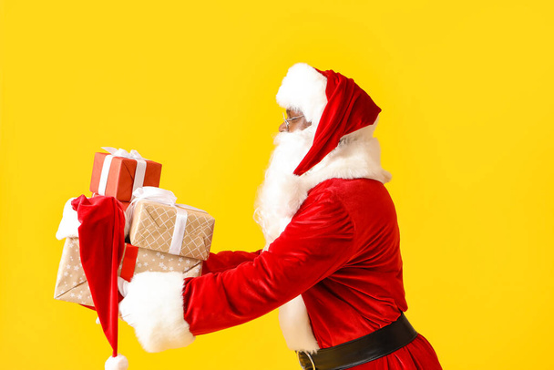 Santa Claus afroamericano con regalos sobre fondo de color - Foto, Imagen
