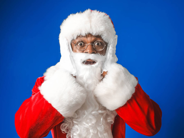 Приголомшений афро-американський Санта Клаус на кольоровому фоні - Фото, зображення