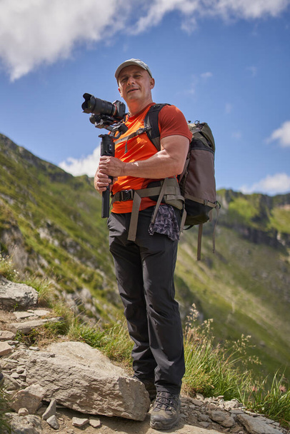 Professional videographer shooting with a gimbal high in the mountains - Foto, immagini