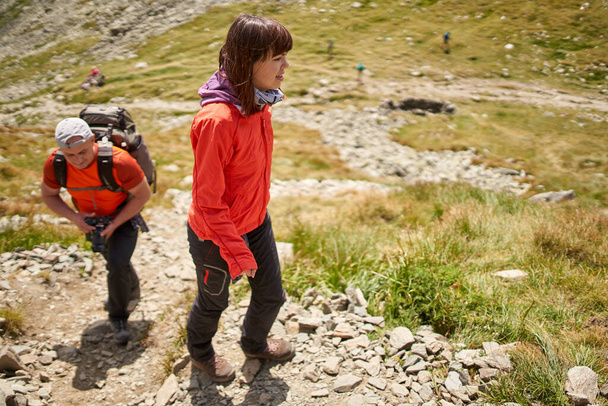 Family hiking into the mountains with backpacks - Foto, imagen