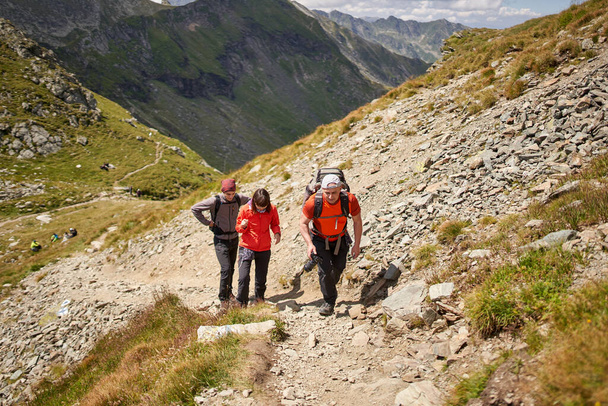 Family hiking into the mountains with backpacks - Foto, Bild