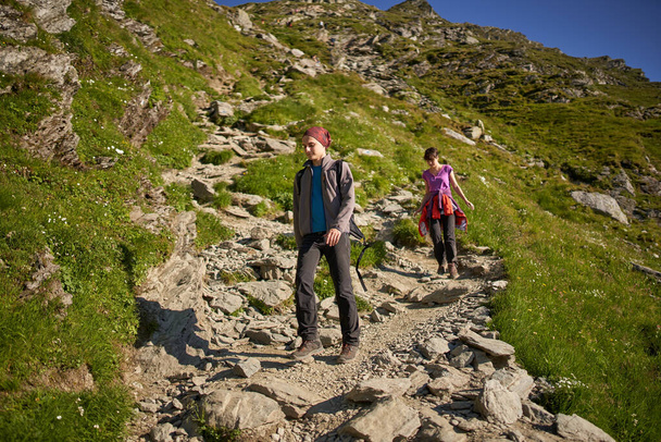 Young couple of hikers on a trail in the mountains - Foto, immagini
