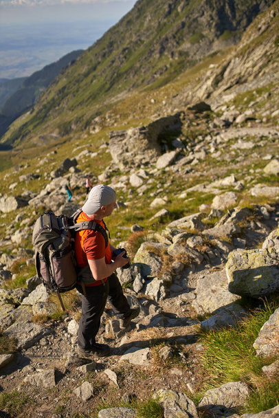 Man hiker with large backpack hiking into the mountains - Foto, immagini