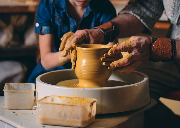 Pottery workshop. Grandpa teaches granddaughter pottery. Clay modeling - Foto, imagen