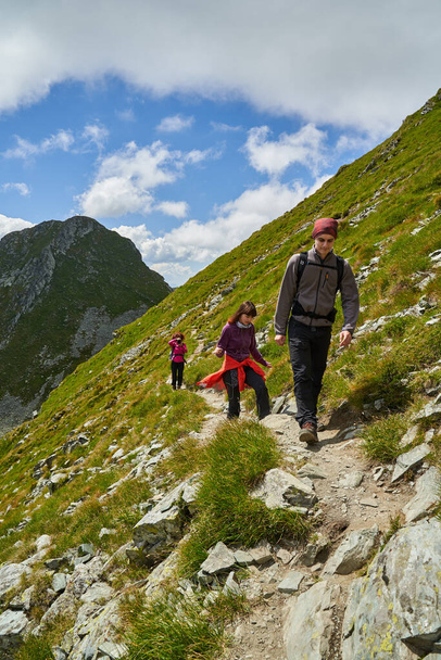 Family of hikers climbing a steep path into the mountains - Foto, Imagem