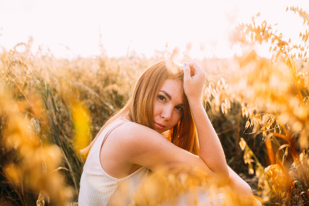 red-haired smiling girl in the field - Foto, afbeelding