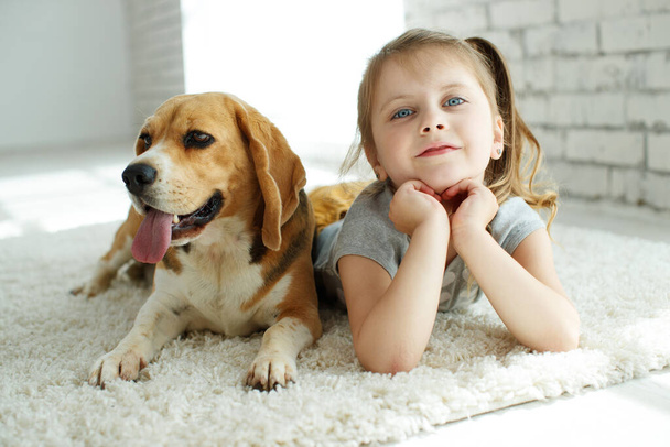 Little girl with a dog at home. - Zdjęcie, obraz