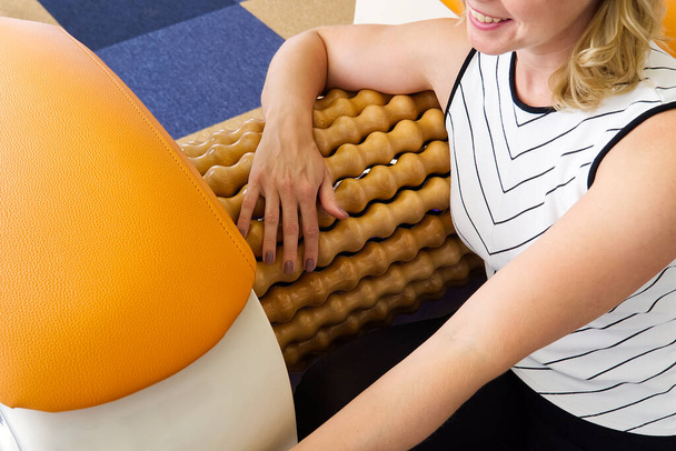 kézmasszázsos nő. Roll Masszázs gép egy módja annak, hogy alakítsák az alakot. Bőrápolás, testápolás. modern relaxációs masszázsfelszerelés. - Fotó, kép