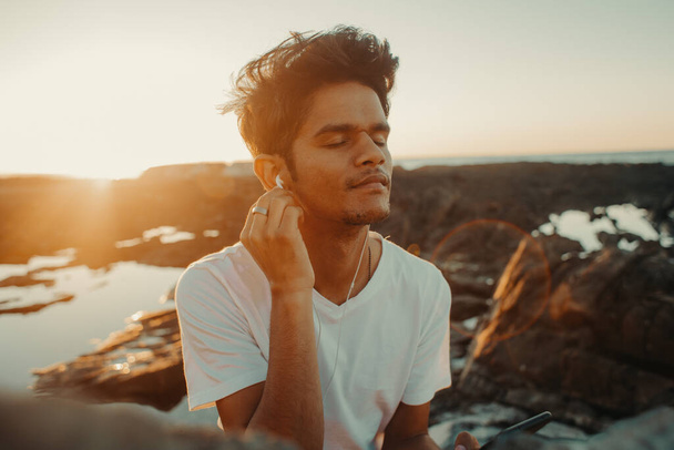 νεαρός άνδρας με ακουστικά που ακούει μουσική  - Φωτογραφία, εικόνα