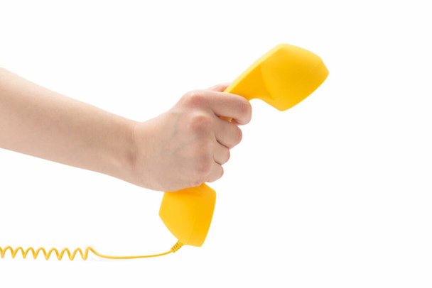 Yellow handset in woman hand isolated on white. Copy space. - Fotografie, Obrázek