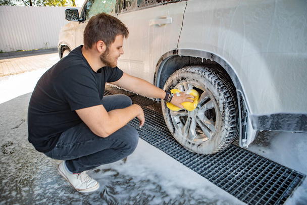 homme nettoyage voiture avec éponge jaune. concept de lavage de voiture. espace de copie - Photo, image