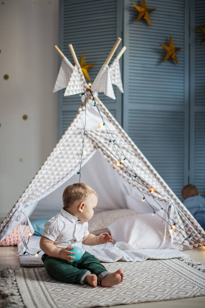 Adorable infant boy playing with kids tent in cozy blue playroom - Фото, зображення