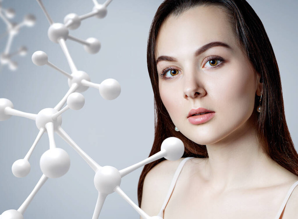 Beautiful woman near big white molecule chain. - Photo, Image