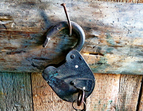 Una vieja cerradura de granero con llaves, en un cobertizo de madera, colgando de un gran clavo. Foto de primer plano. - Foto, imagen